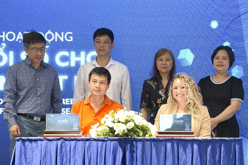 Ông Hoàng Việt Thắng (áo cam) - Giám đốc Trung tâm cung ứng nguồn lực số đại diện FUNiX và bà Amanda Saville - Phó Giám đốc dự án US-SEGA/WISE (áo vàng) trong lễ ký kết hợp tác giữa hai đơn vị.