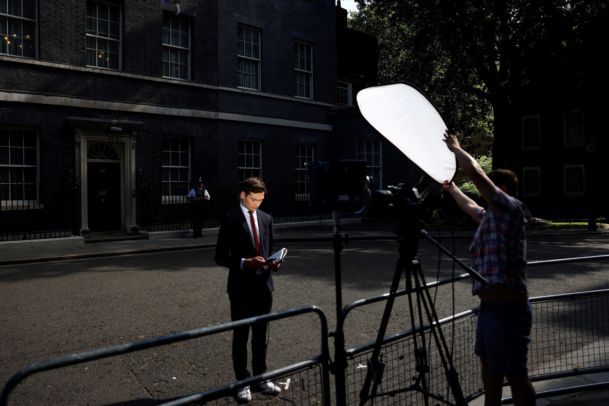 Một phóng viên chờ phát sóng trực tiếp bên ngoài số 10 Phố Downing ở London, Anh ngày 24.6.2022. Ảnh: AFP
