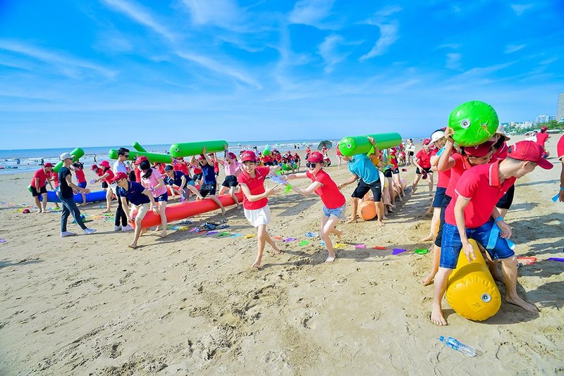 Du khách trong nước tham gia một trò chơi tập thể trên bờ biển trong chương trình du lịch MICE. (Ảnh HUỆ VŨ)
